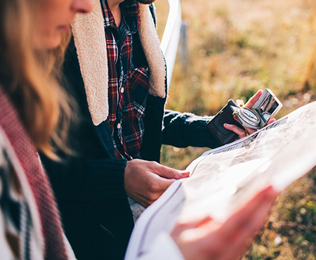 a male and female couple use a map to to find their destination